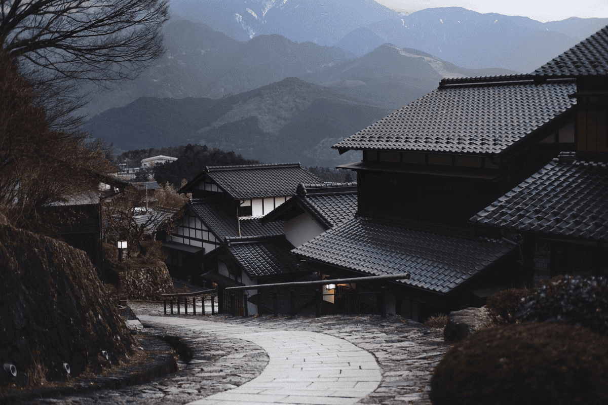 Public Qwen Image 3 reference showing a mountain village with tiled roofs and a winding stone road.